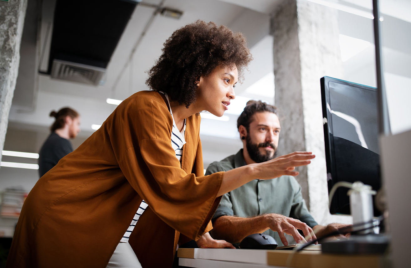 a man and a woman are looking at a computer screen