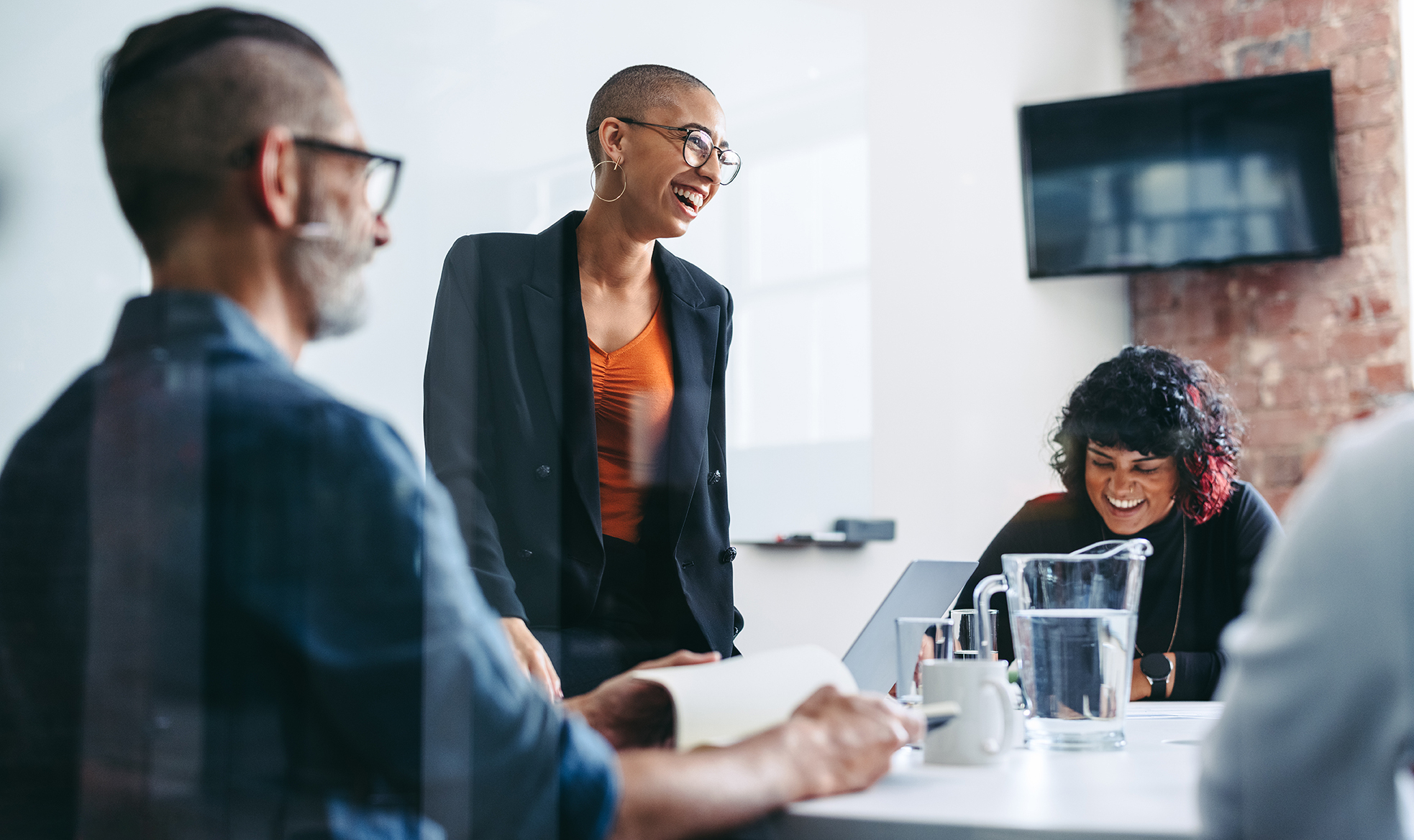 Group of people laughing during a team meeting.