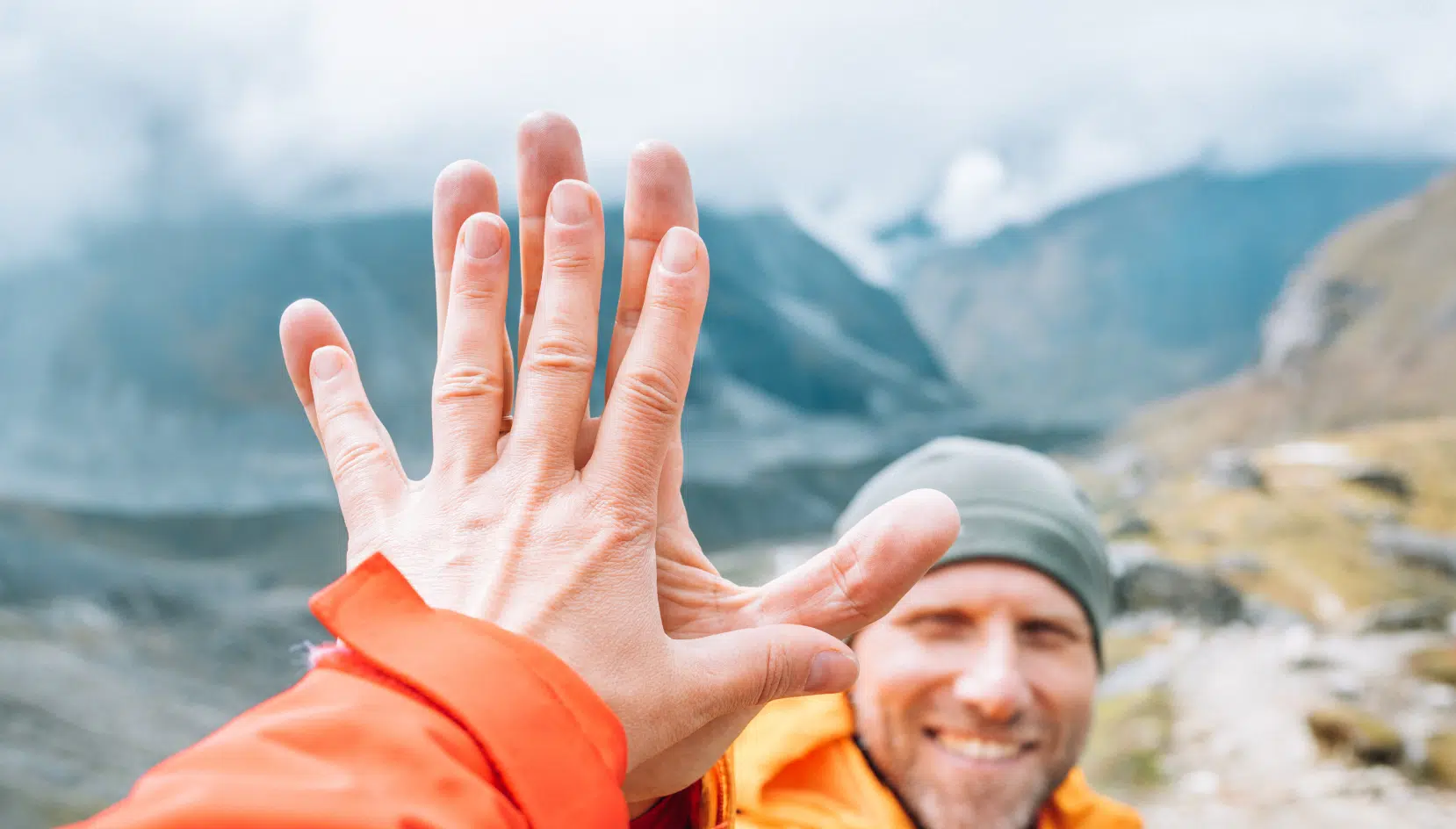 High-five from 2 friends on mountain hike