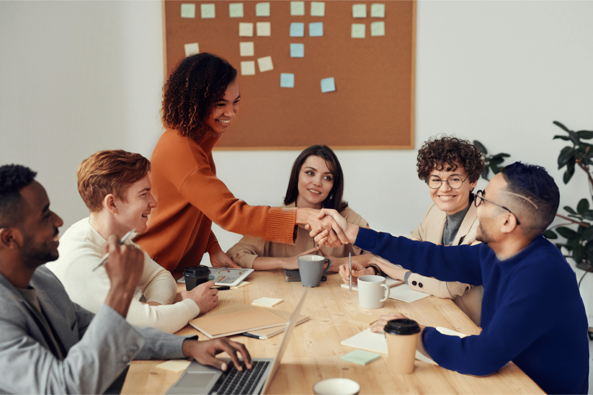 business_services a group of people sitting around a table shaking hands