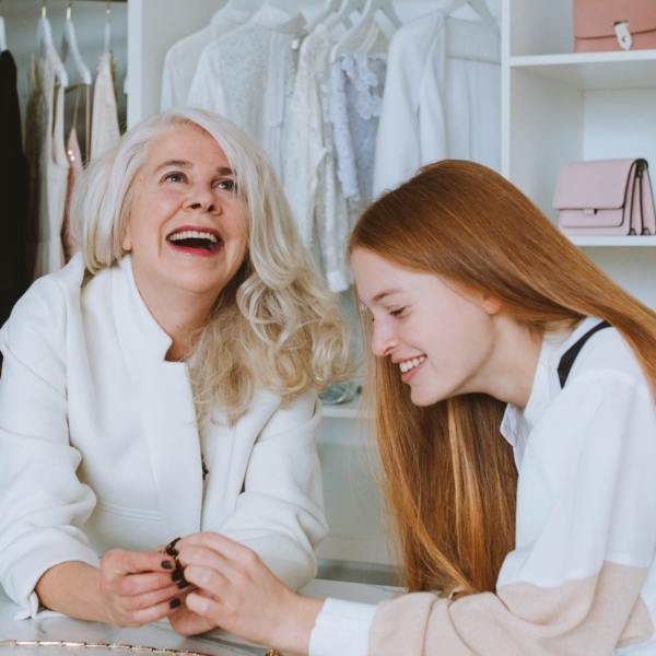 Two women smiling and laughing while shopping.