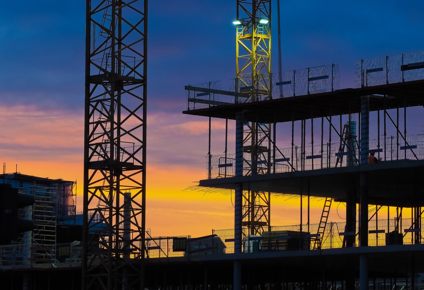 a construction site with a sunset in the background