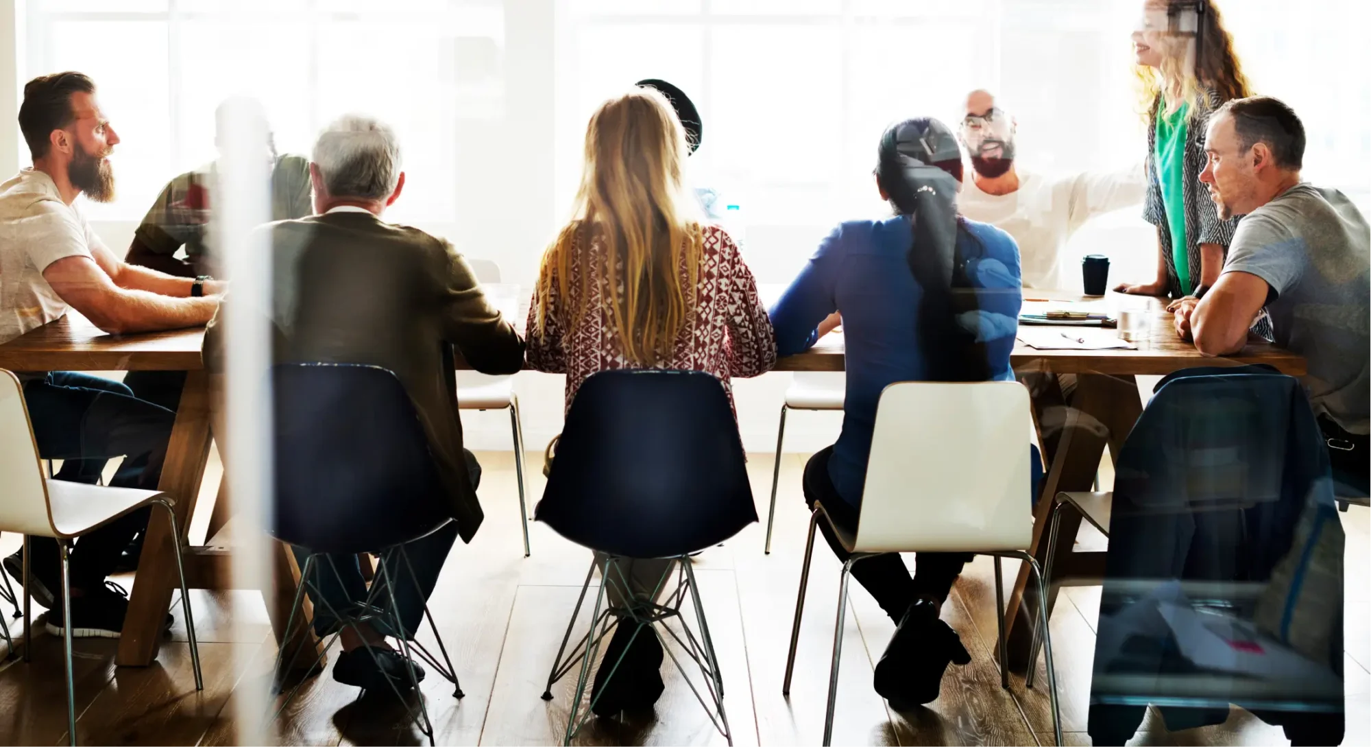 A group of colleagues discussing business in a meeting room.