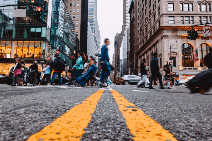 a group of people crossing a street with a sign that says no standing