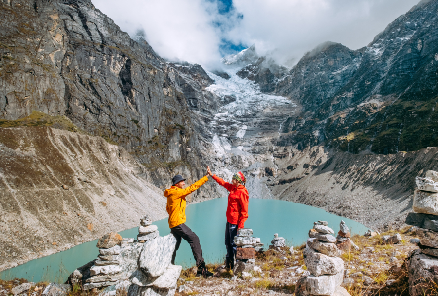 two people giving each other a high five in front of a lake
