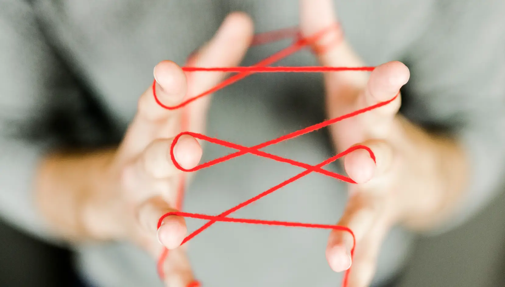 Persons hands tied with a red string.