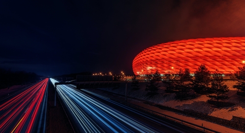a large red stadium is lit up at night