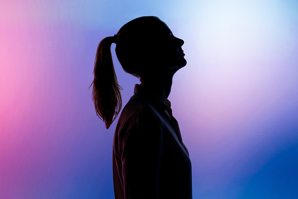 Silhouette of a woman on a brightly colored background.