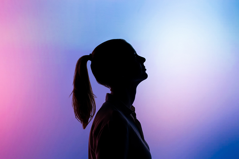 Silhouette of a woman on a brightly colored background.