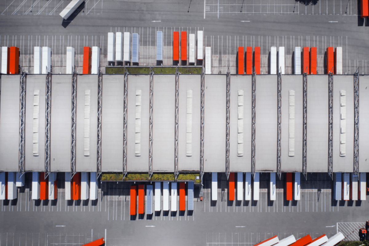 an aerial view of a warehouse with red and white containers