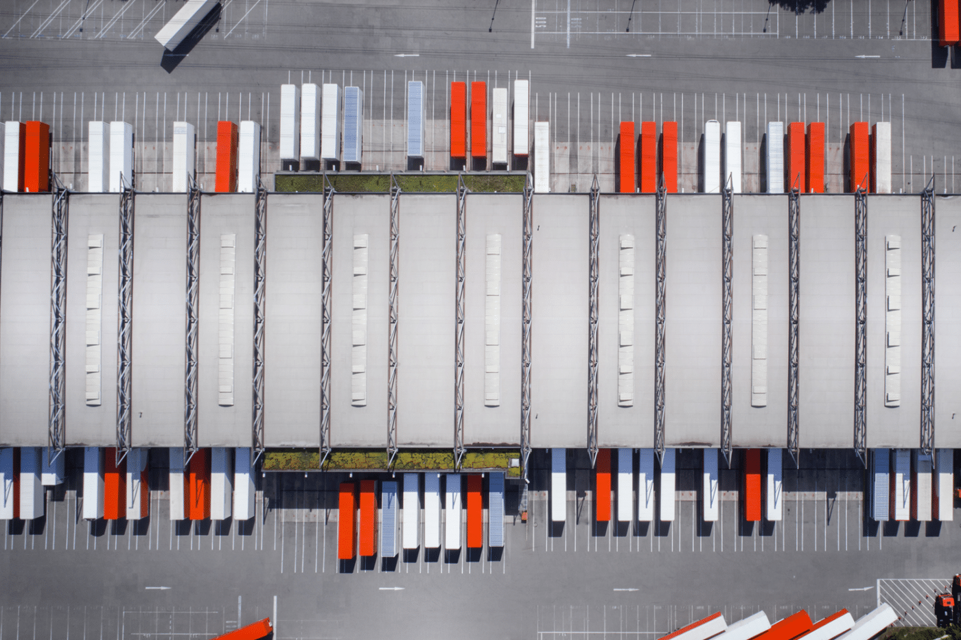 an aerial view of a warehouse with red and white containers